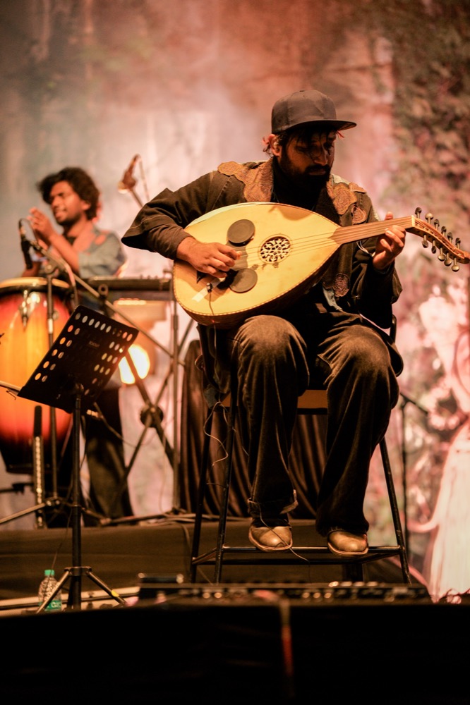 An oud player performing live on stage